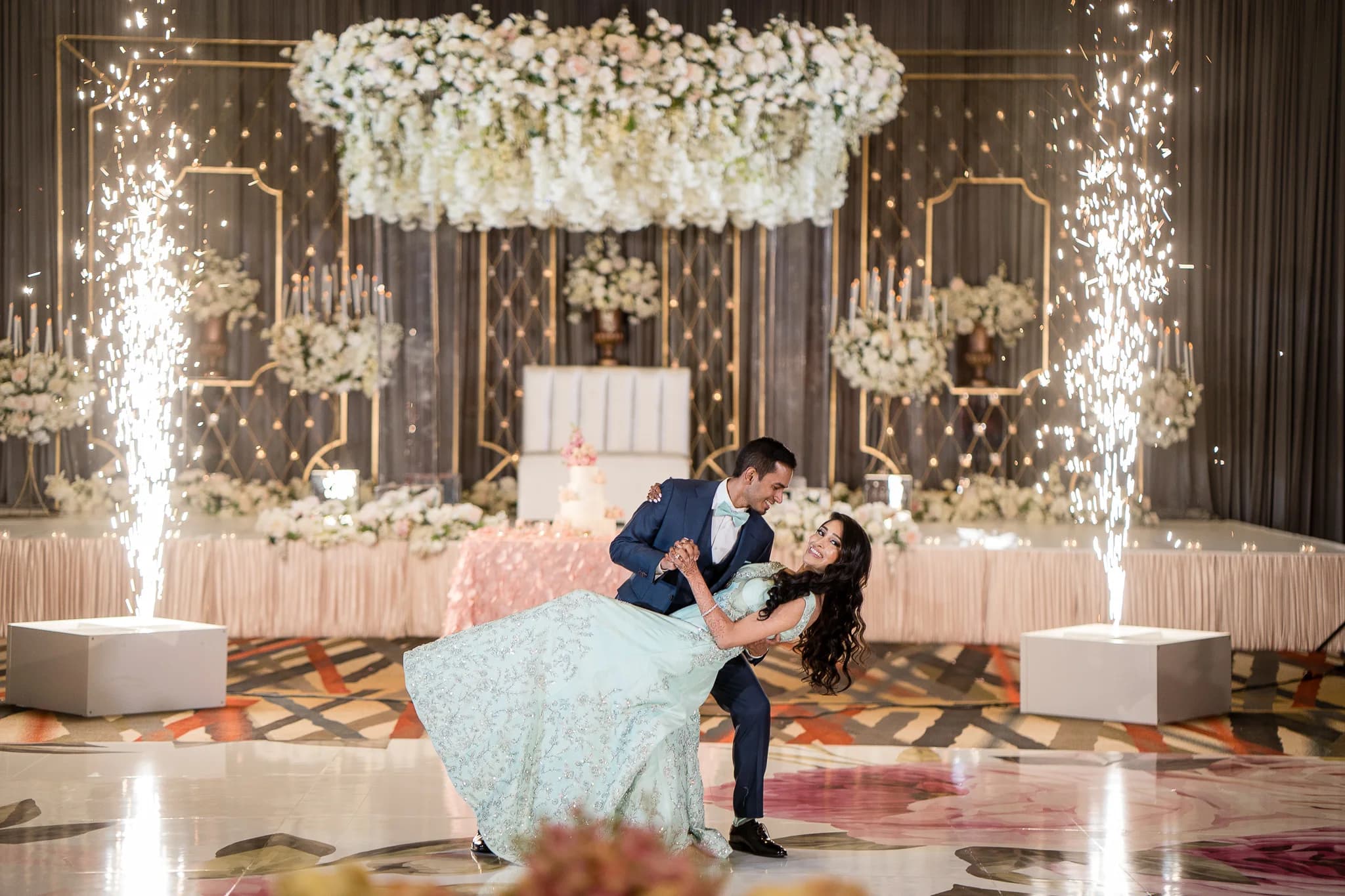 Newlyweds sharing their first dance between cold-spark fountains
