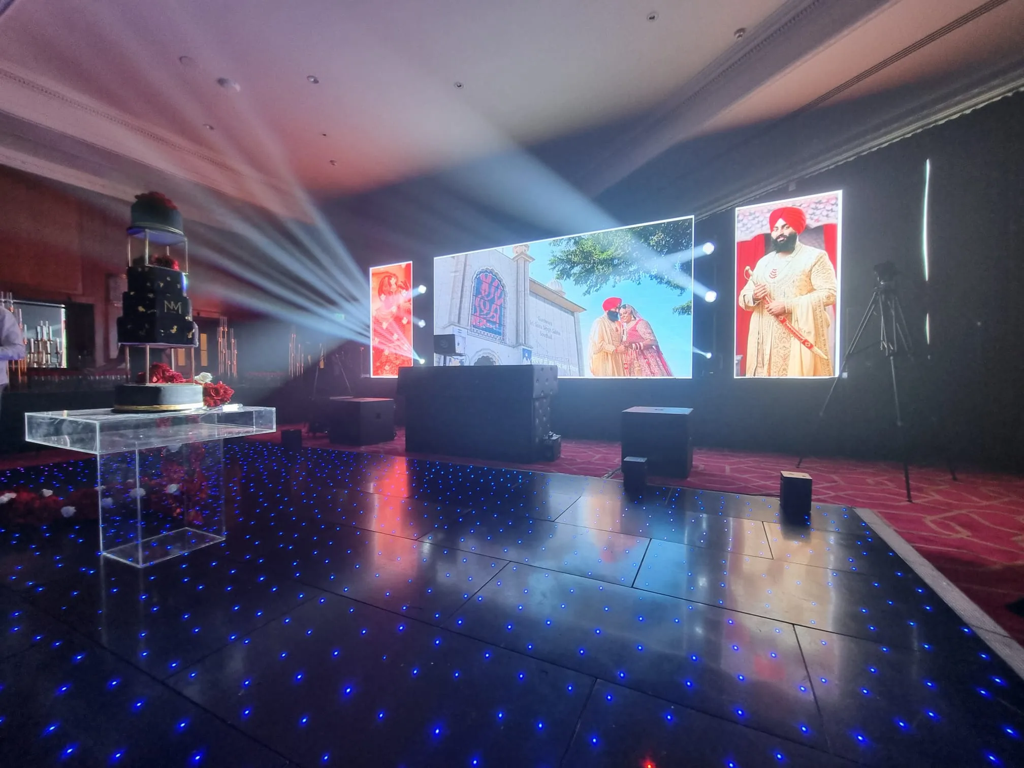 Luxury wedding reception with LED screens and a blue starlit dance floor