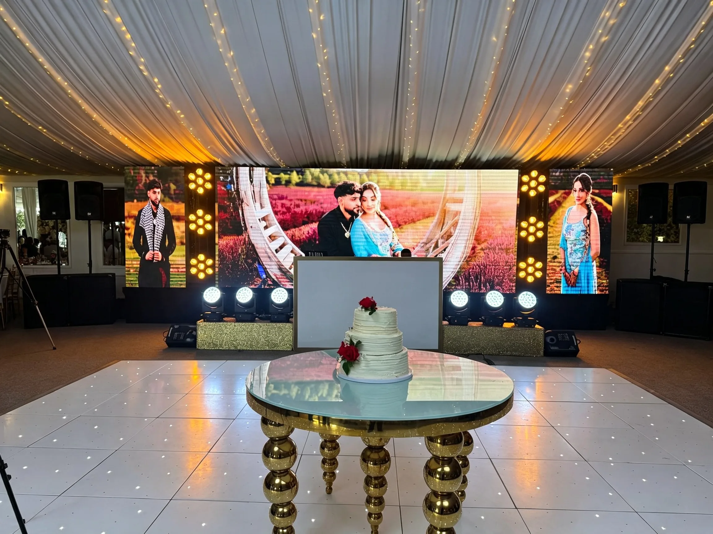 Wedding cake beside an LED wall and illuminated dance floor